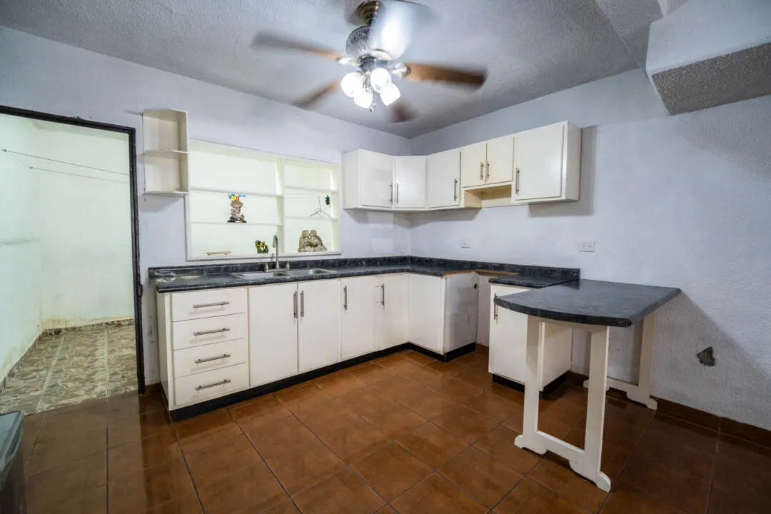 Casa Venados Daniel-3 Cocina con cubierta oscura y gabinetes blancos — Casa en venta Los Venados