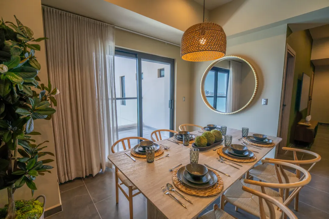 Depa Akoya Renta Fer-74 Comedor con espejo y sillas de mimbre en departamento Akoya Sky Living Mazatlán