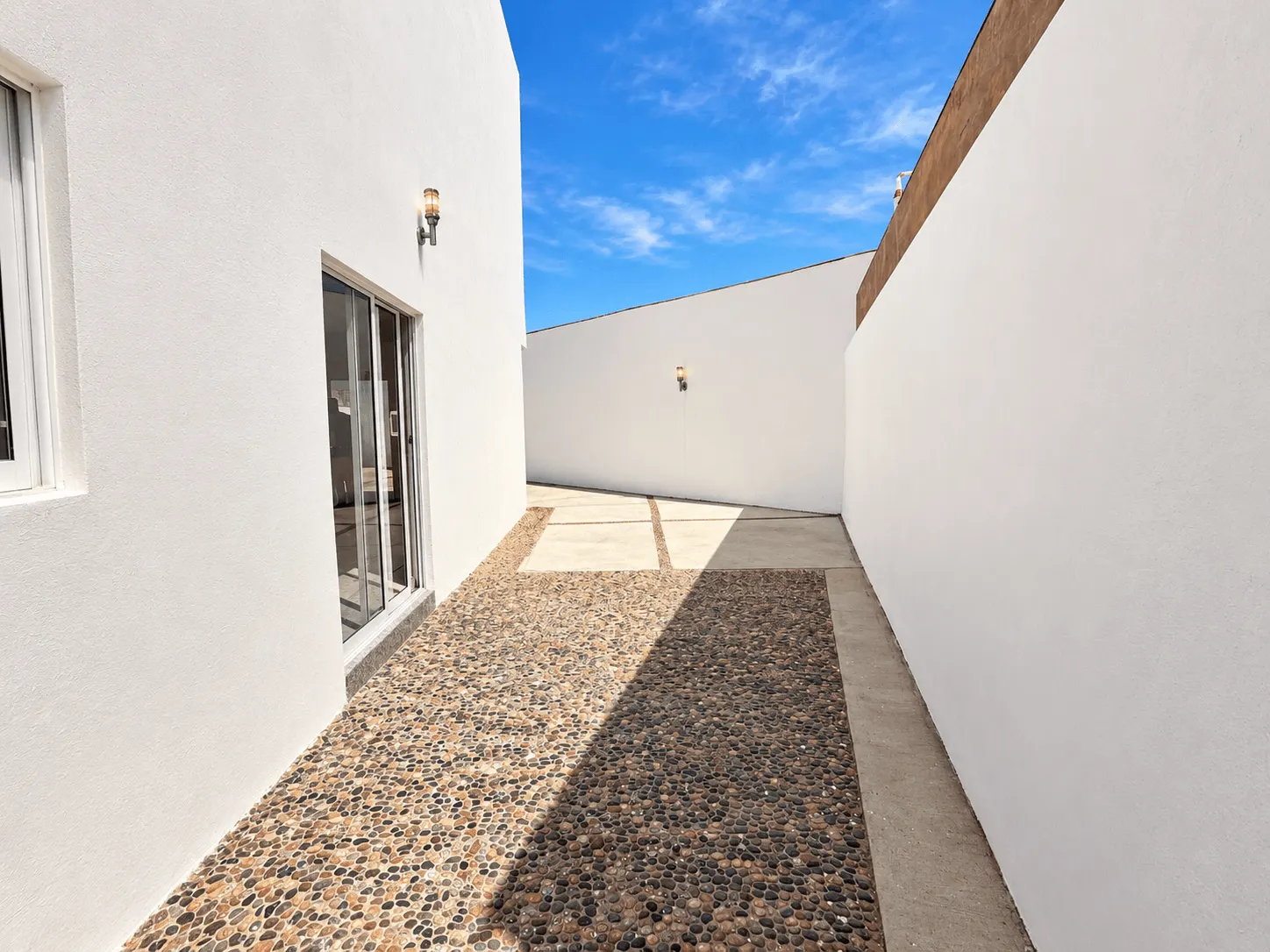 casa-renta-el-secreto-sabalo-country-mazatlan-moises-ocean-capital-group11 Patio lateral con acabado de piedra y acceso a la entrada de la casa
