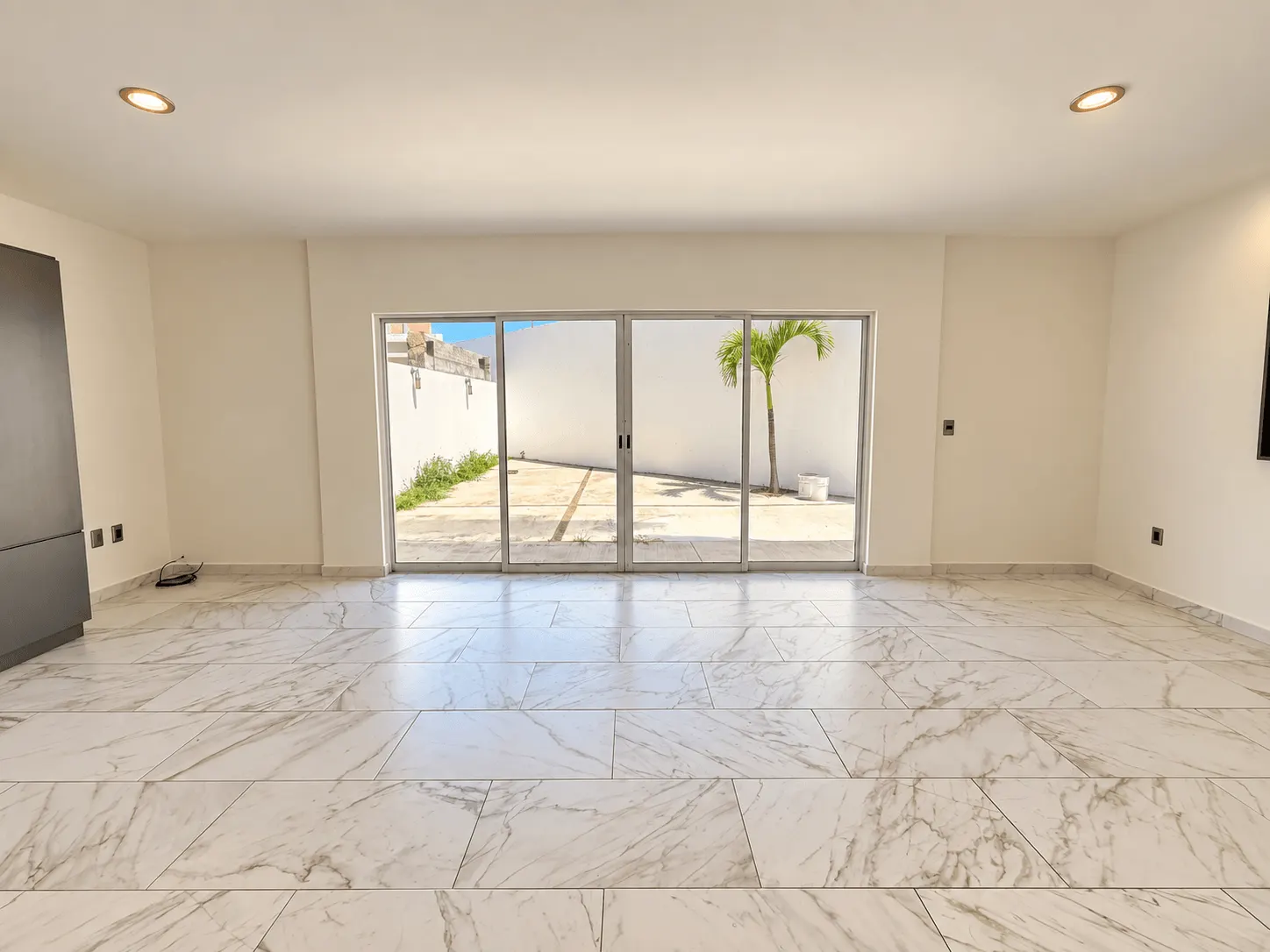 casa-renta-el-secreto-sabalo-country-mazatlan-moises-ocean-capital-group21 Sala amplia con piso de mármol y puerta corrediza hacia el patio