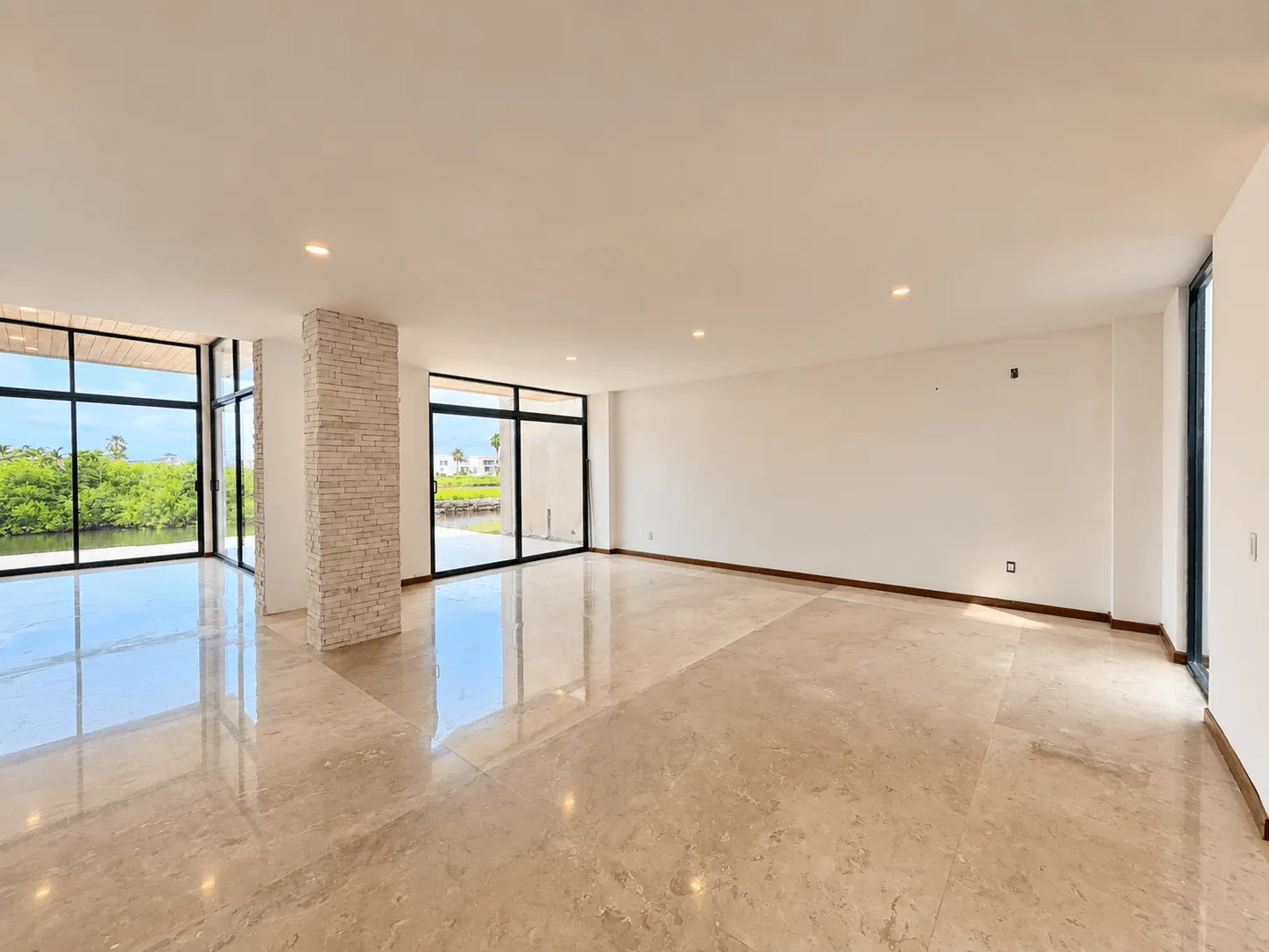 casa-venta-el-cid-mazatlan-vista-marina11 Espacio con ventanales y columna de piedra
