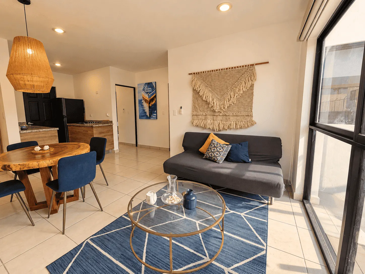 departamento-venta-azul-marino-mazatlan-cerritos-olaya-yoli6 Sala con sofá, mesa de centro y comedor de madera en departamento amueblado en venta en Mazatlán