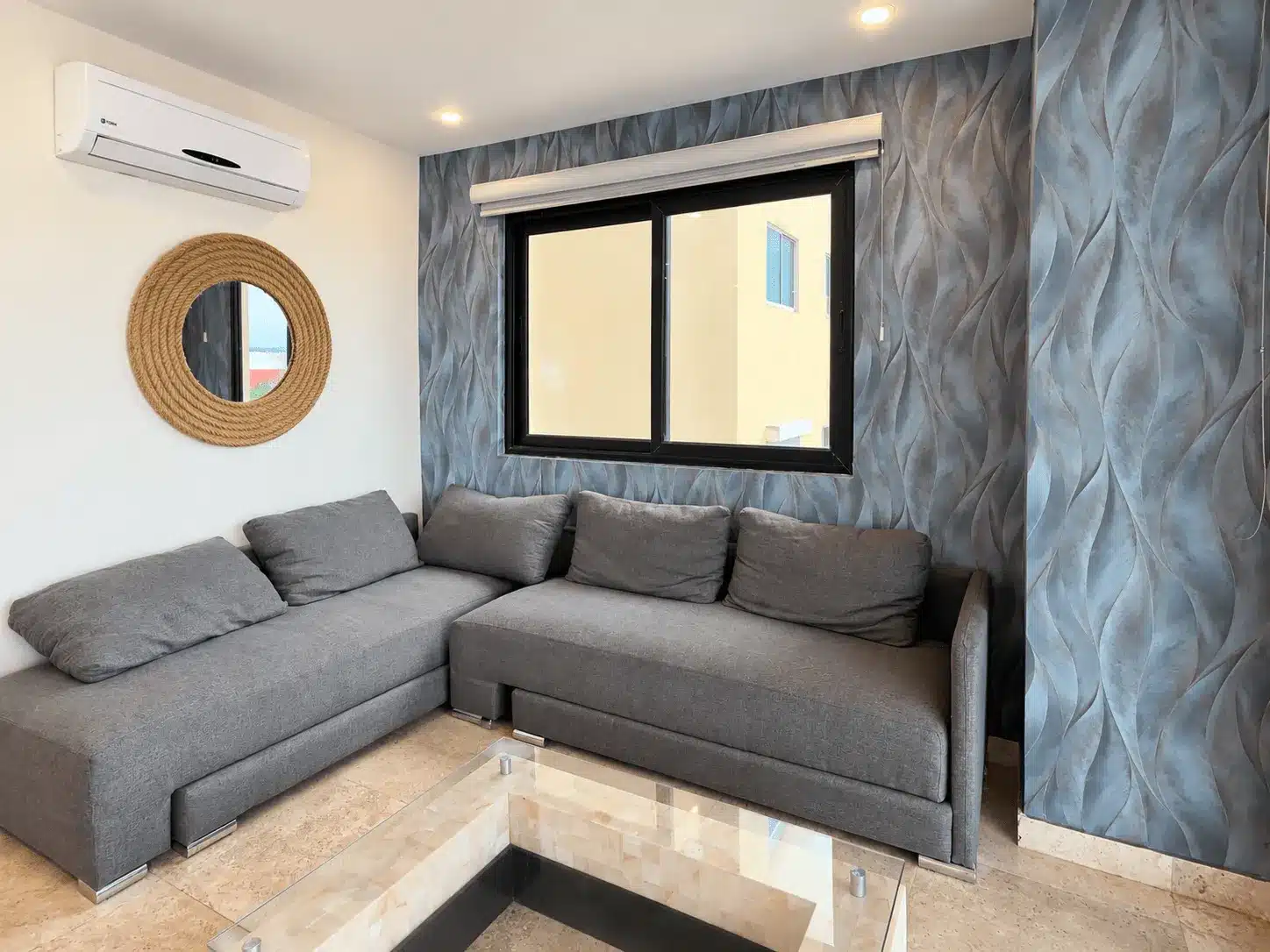 departamento-venta-malecon-central-102-mazatlan-bienes-raices26 Sala con sofá gris y ventana con vista a la ciudad, Torre Central 102