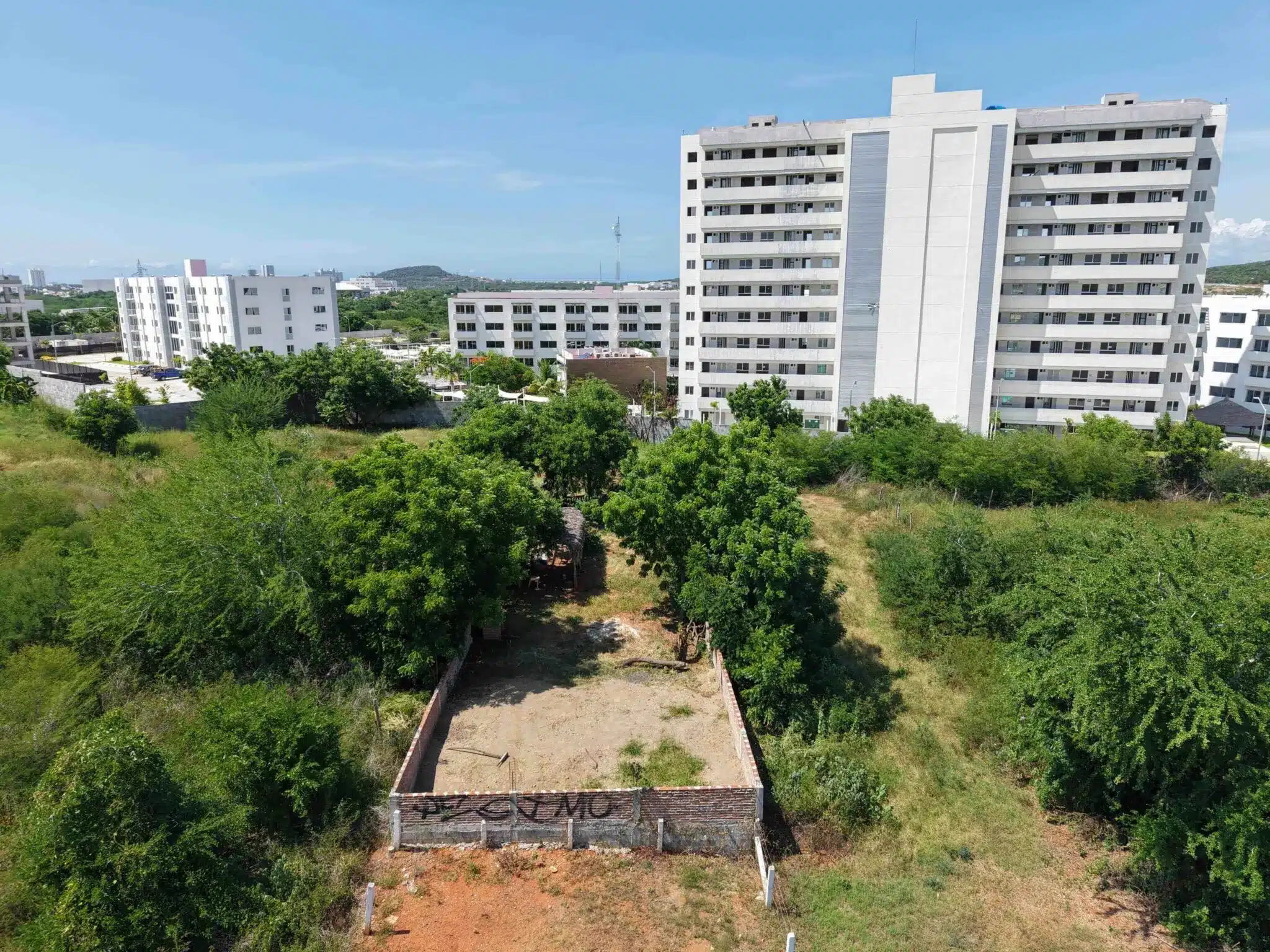 terreno-venta-villa-universidad-galerias-mazatlan-luis4 Terreno en Marina Universidad, Mazatlán, visto desde el aire junto a edificio residencial