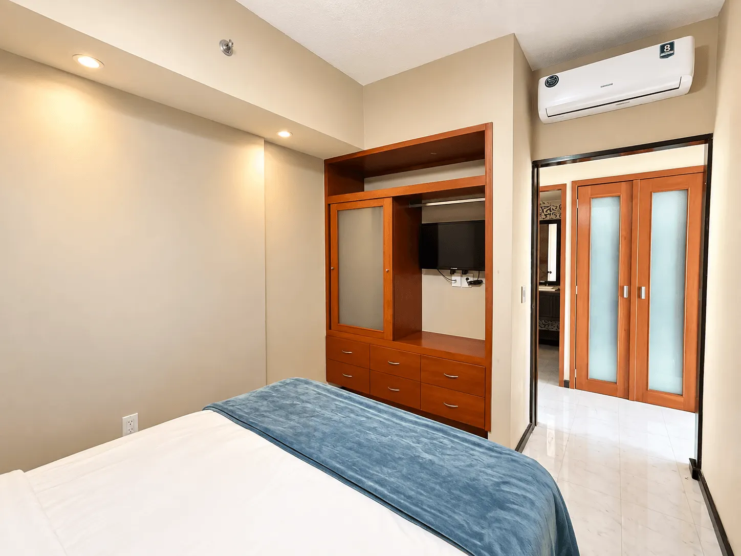 departamento-park-royal-mazatlan-cerritos-vista-al-mar-playa18 Recámara con mueble de madera con TV y aire acondicionado en departamento amueblado en Park Royal Mazatlán