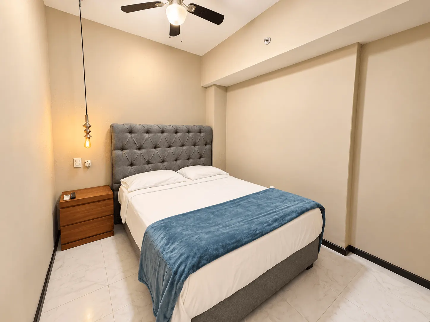 departamento-park-royal-mazatlan-cerritos-vista-al-mar-playa19 Recámara con cabecera capitoné, cobertor azul y buró de madera en departamento en venta en Park Royal Mazatlán