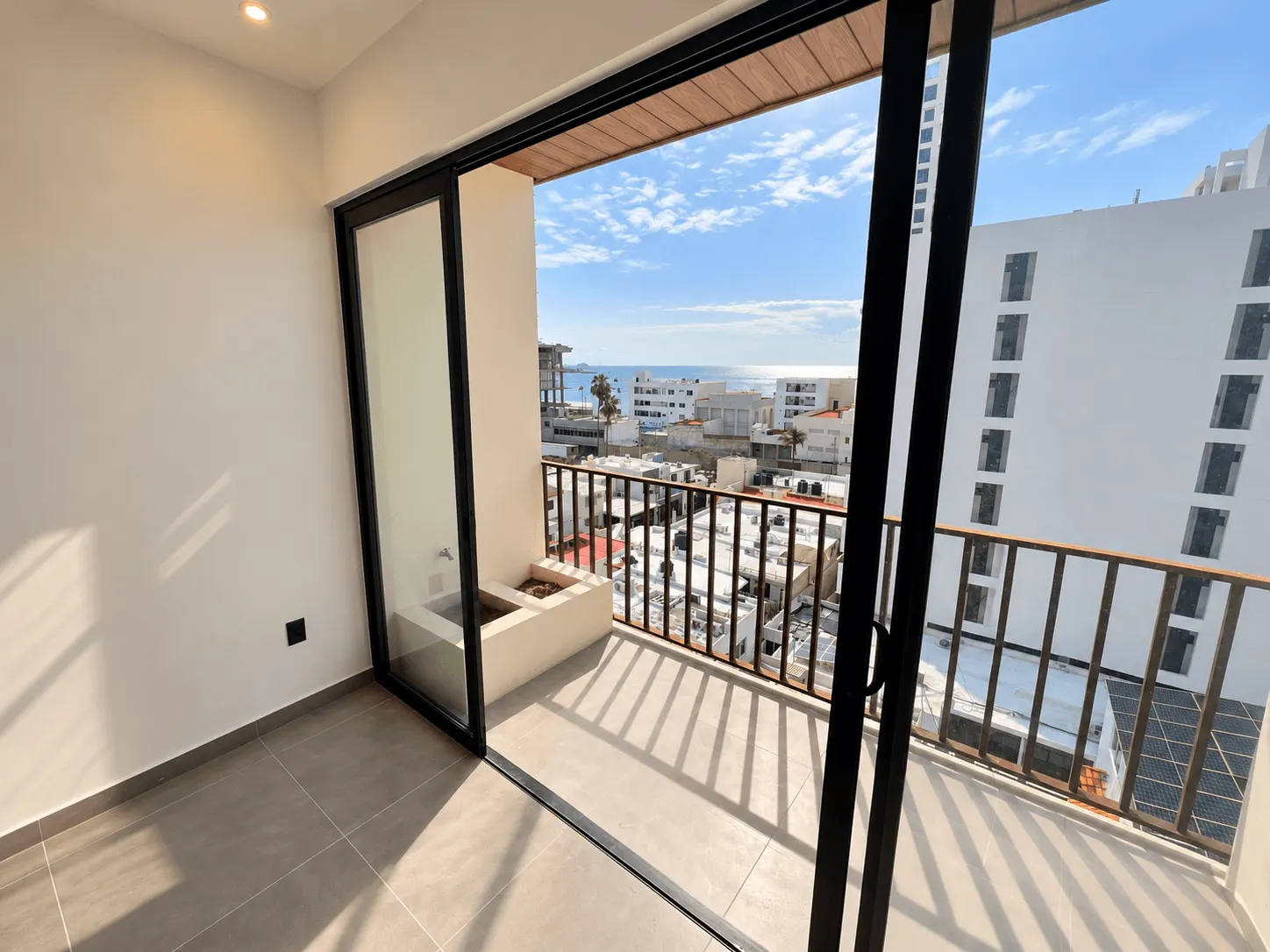 departamento-san-sebastian-palos-prieros-en-venta-mazatlan-malecon-13 Balcón con barandal y puerta corrediza en departamento de Torre San Sebastián, Mazatlán